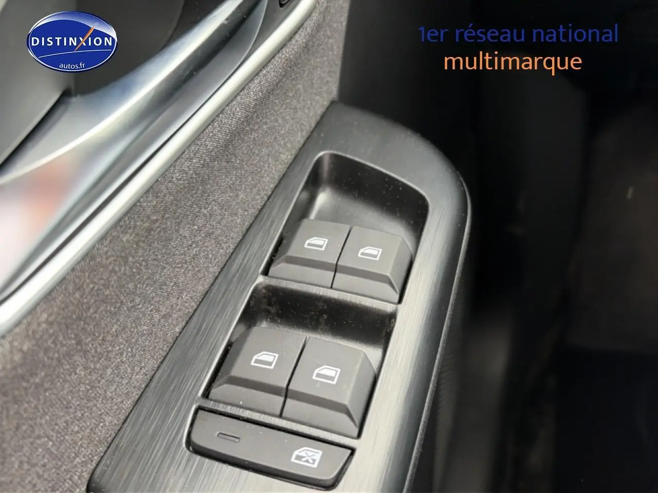 Gros plan sur les commandes des vitres électriques côté gauche d’un MG ZS Hybrid blanc, avec finition noire intérieure.