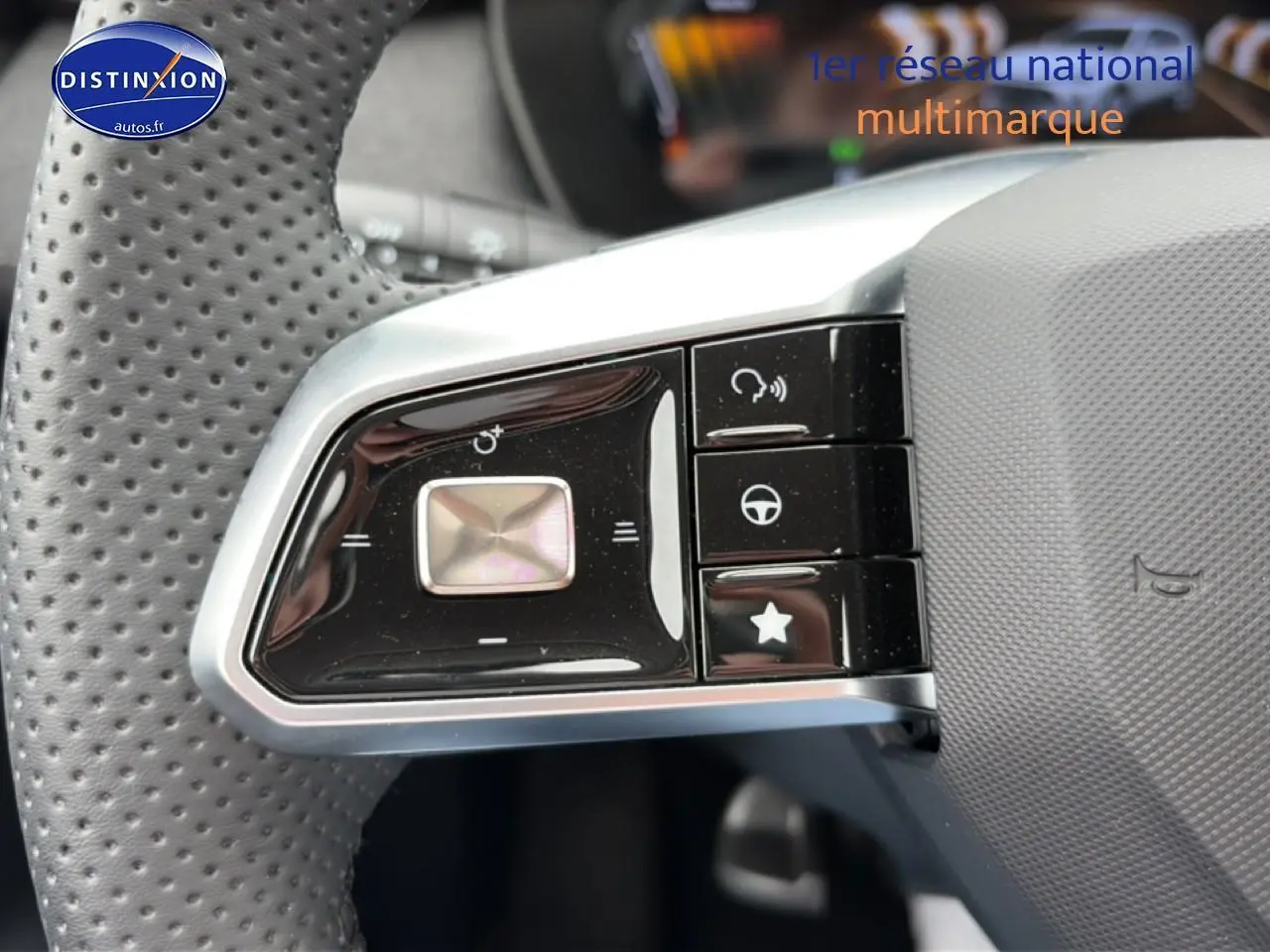 Gros plan sur les commandes noires du volant perforé du MG ZS Hybrid blanc, avec boutons multifonctions visibles.