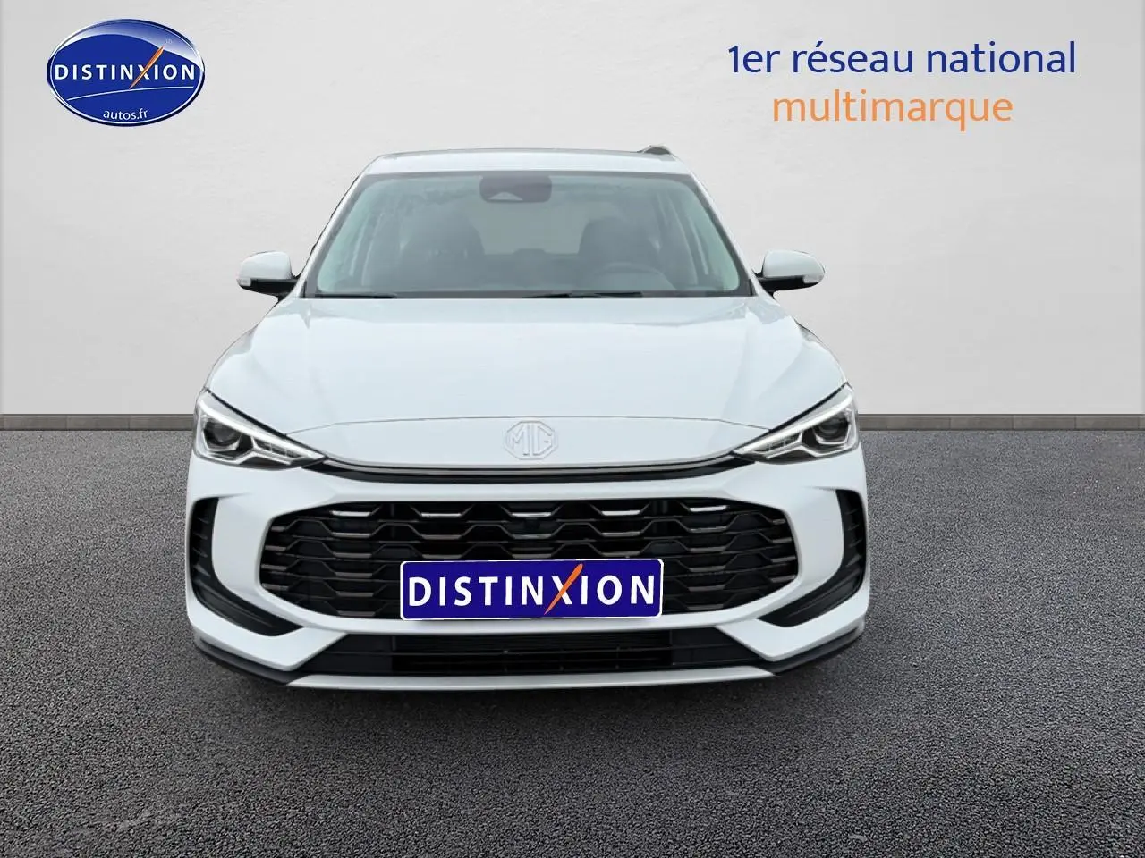 Vue avant d'un MG ZS Hybrid blanc avec calandre noire et phares LED fins, sur fond neutre gris.