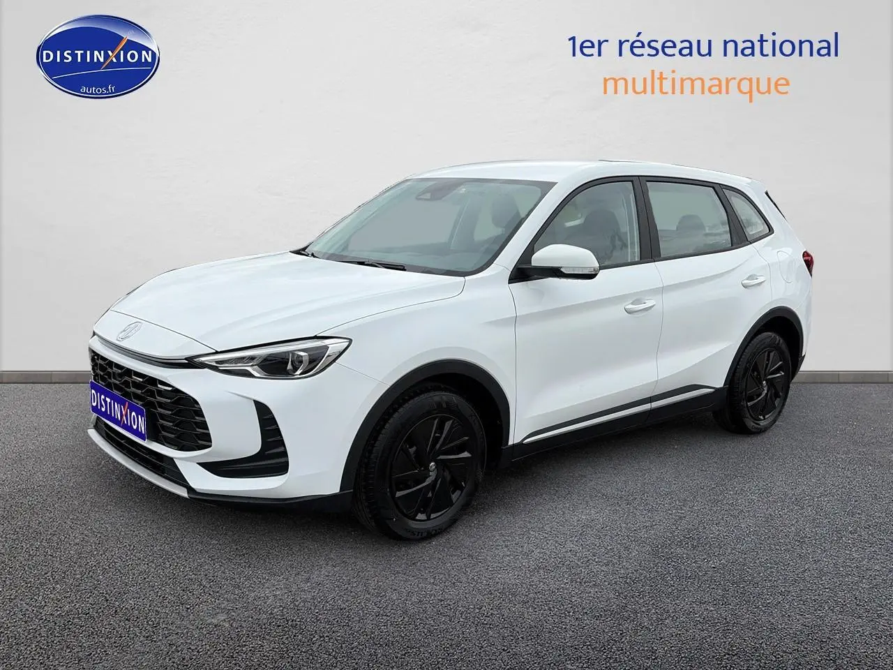 Vue 3/4 avant d'un MG ZS Hybrid blanc avec jantes noires et calandre noire sur fond neutre.