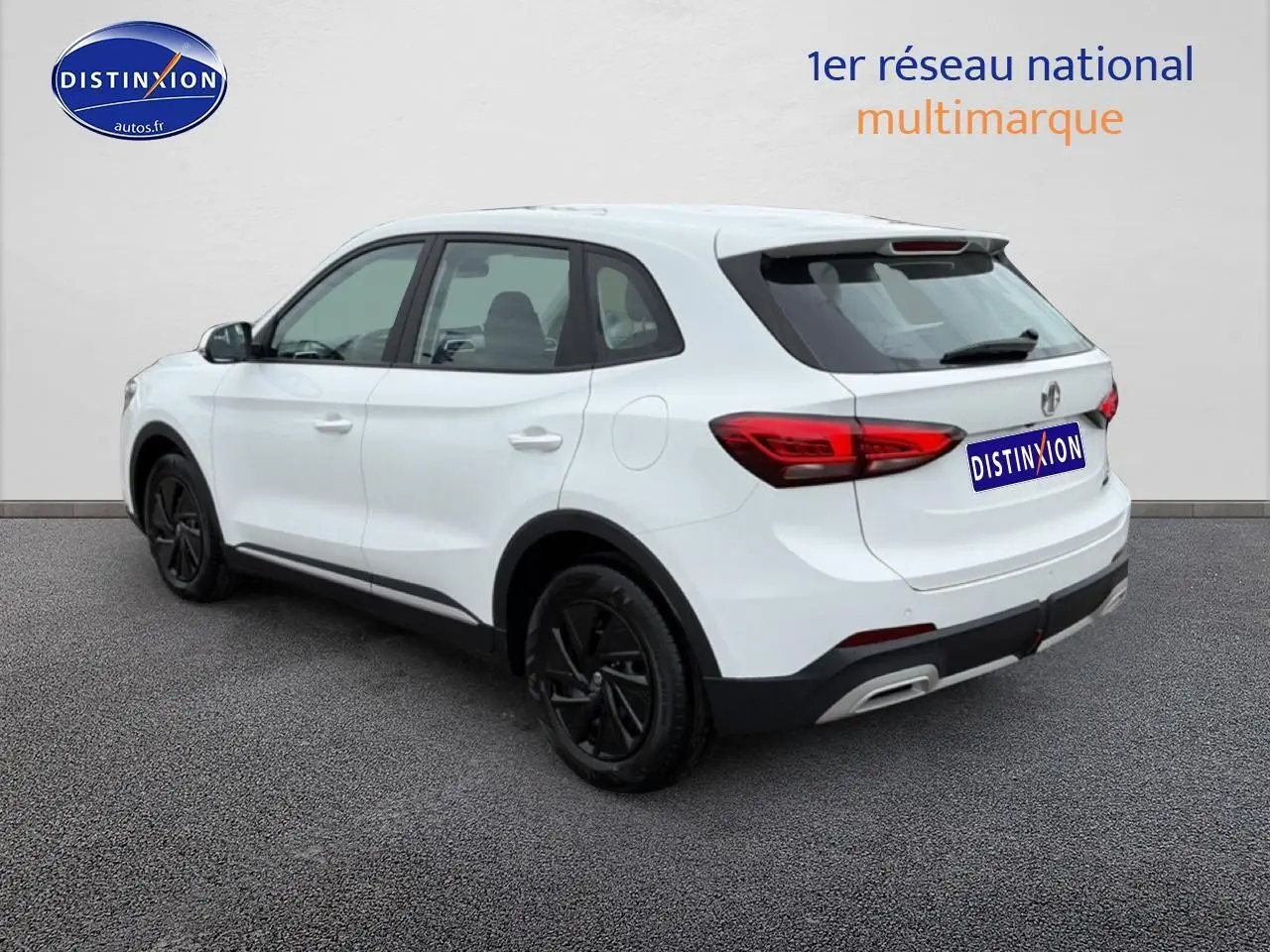 Vue 3/4 arrière droite d’un MG ZS Hybrid blanc avec jantes noires et feux arrière LED distinctifs.