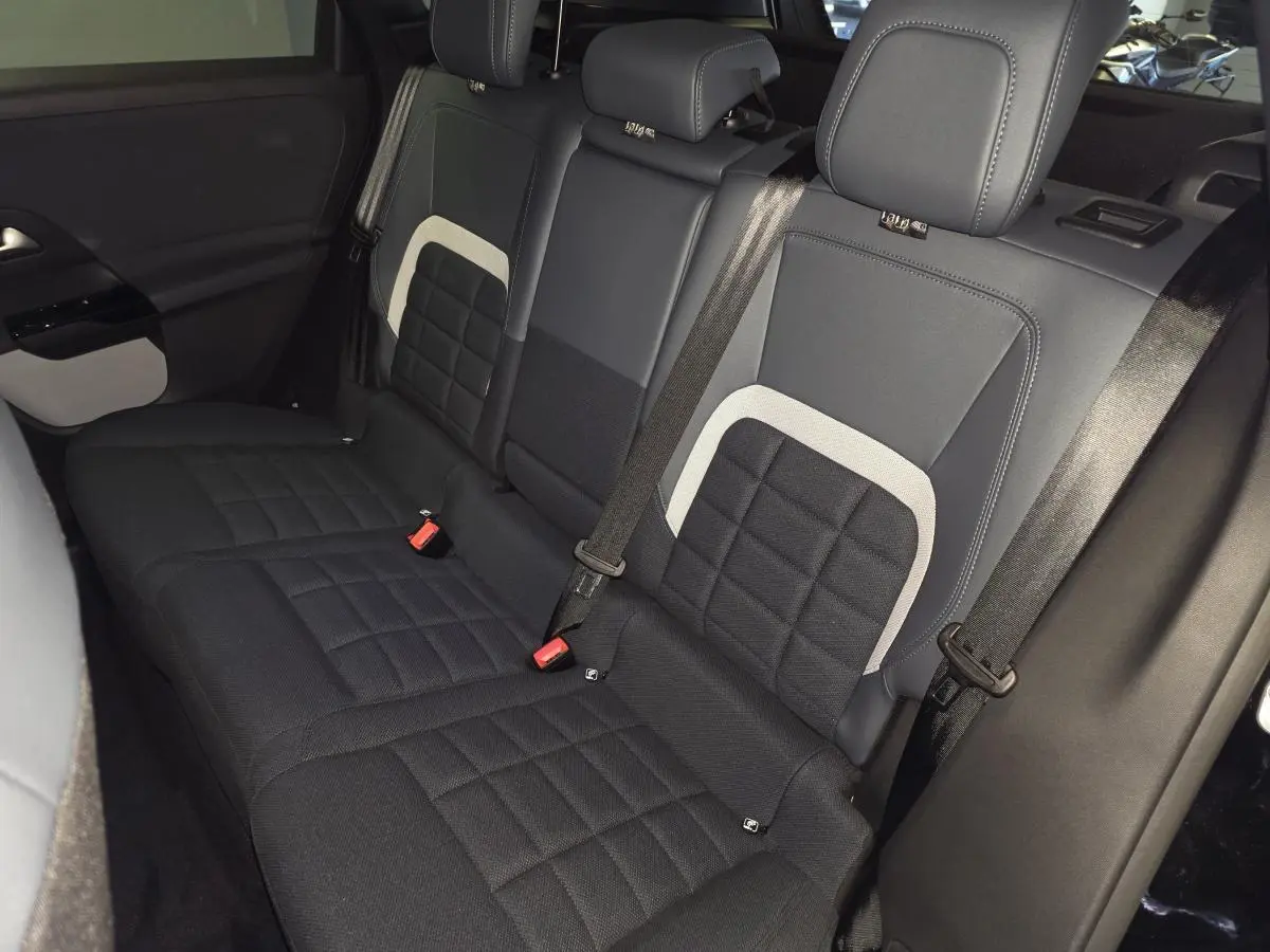 Vue intérieure de la banquette arrière noire et grise du Citroën C5 Aircross 1.2i Hybride 2026 avec ceintures de sécurité.
