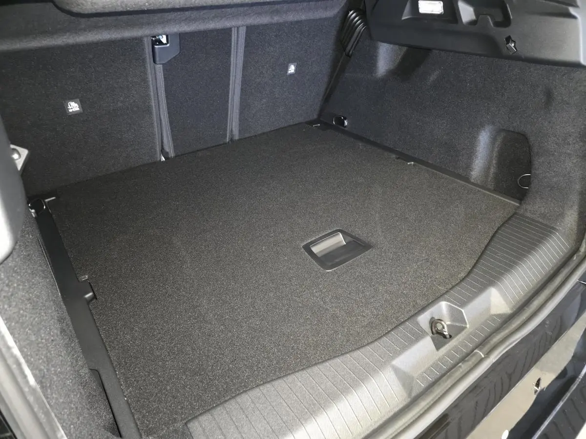 Vue intérieure du coffre spacieux et noir du Citroën C5 Aircross 2026, avec plancher plat et poignée centrale.