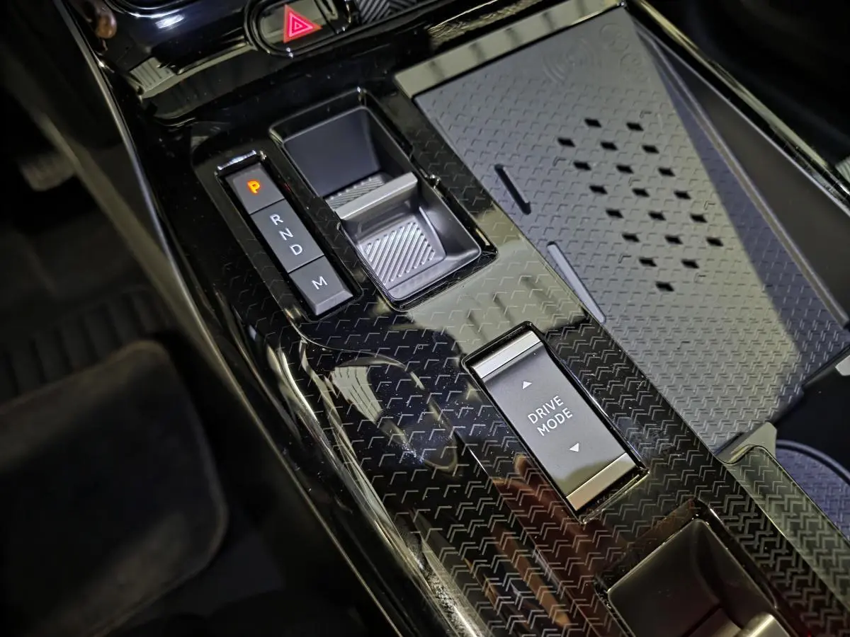 Gros plan sur la console centrale noire brillante du Citroën C5 Aircross 2026 avec sélecteur de vitesses et bouton Drive Mode.