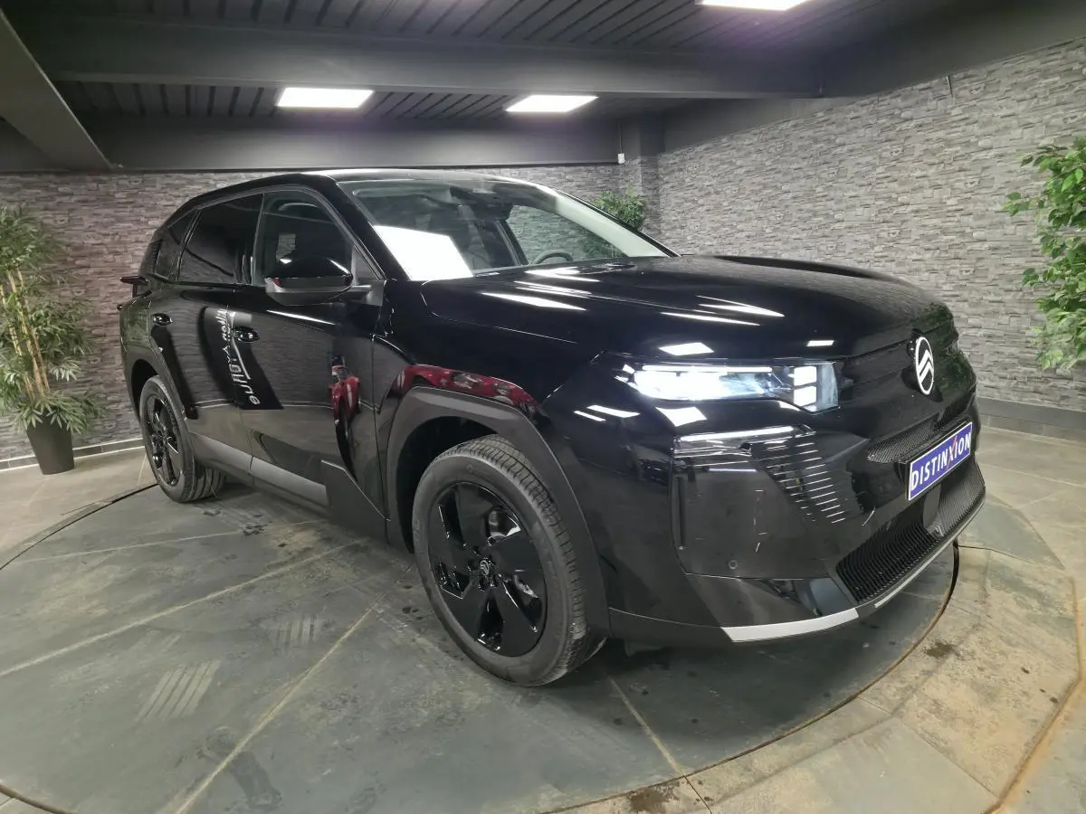 Citroën C5 Aircross noir en 3/4 avant droit, avec jantes noires et calandre brillante dans un showroom.
