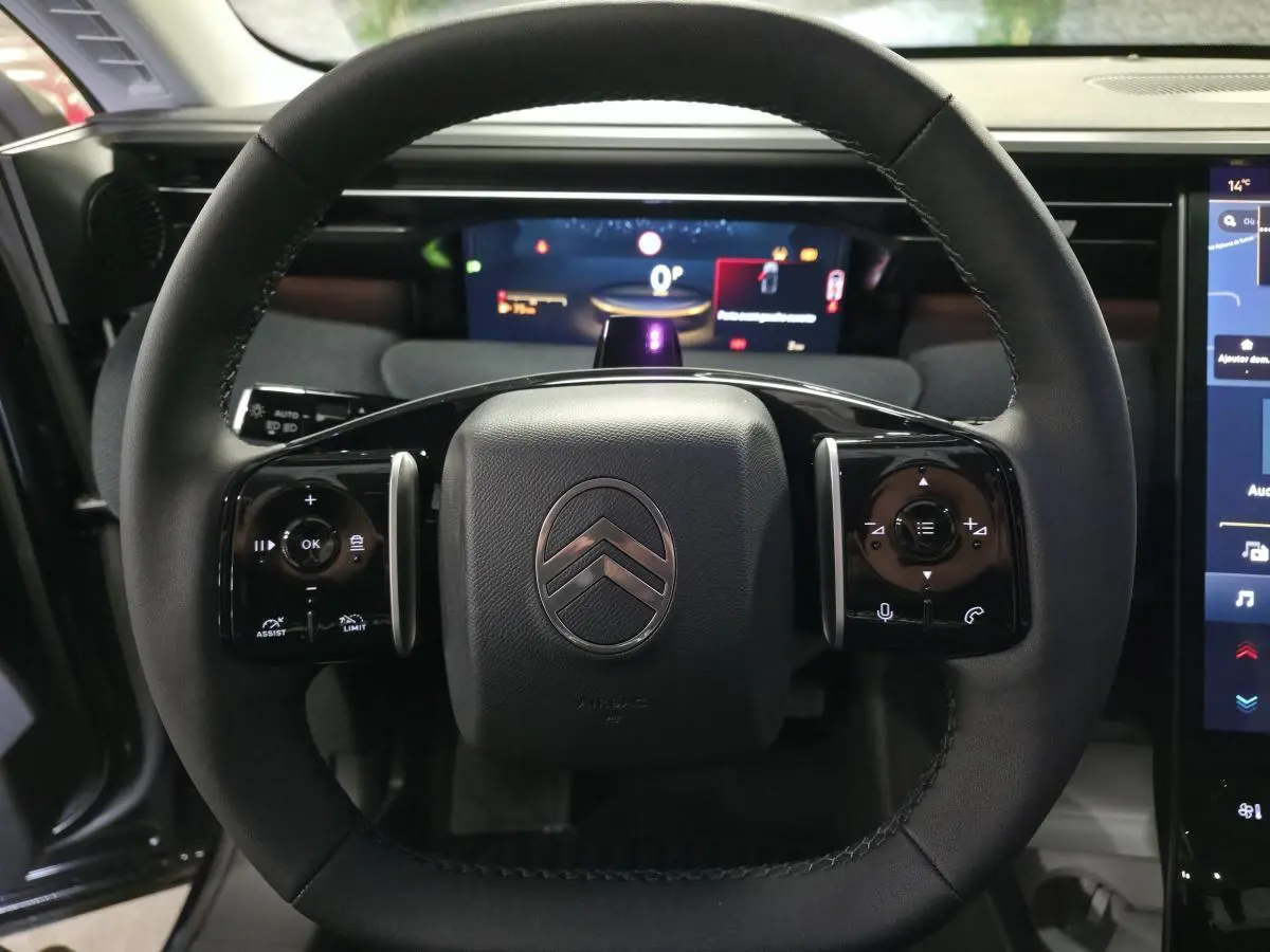 Vue rapprochée du volant noir multifonctions du Citroën C5 Aircross 2026 avec tableau de bord numérique en arrière-plan.