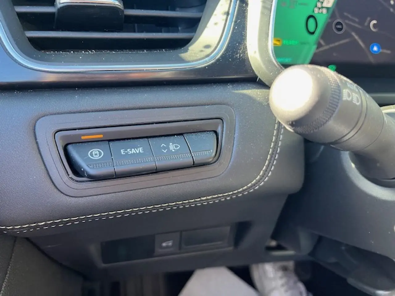 Gros plan sur les commandes noires du tableau de bord côté gauche du Renault Symbioz 2025, avec surpiqûres blanches.