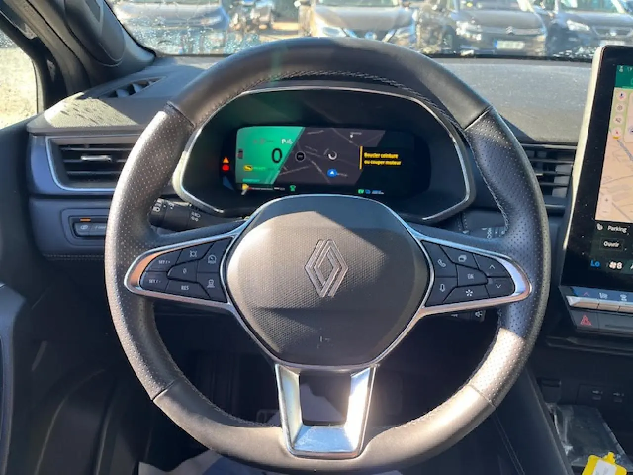 Vue rapprochée du volant noir de la Renault SYMBIOZ 2025 avec tableau de bord numérique et écran tactile latéral.