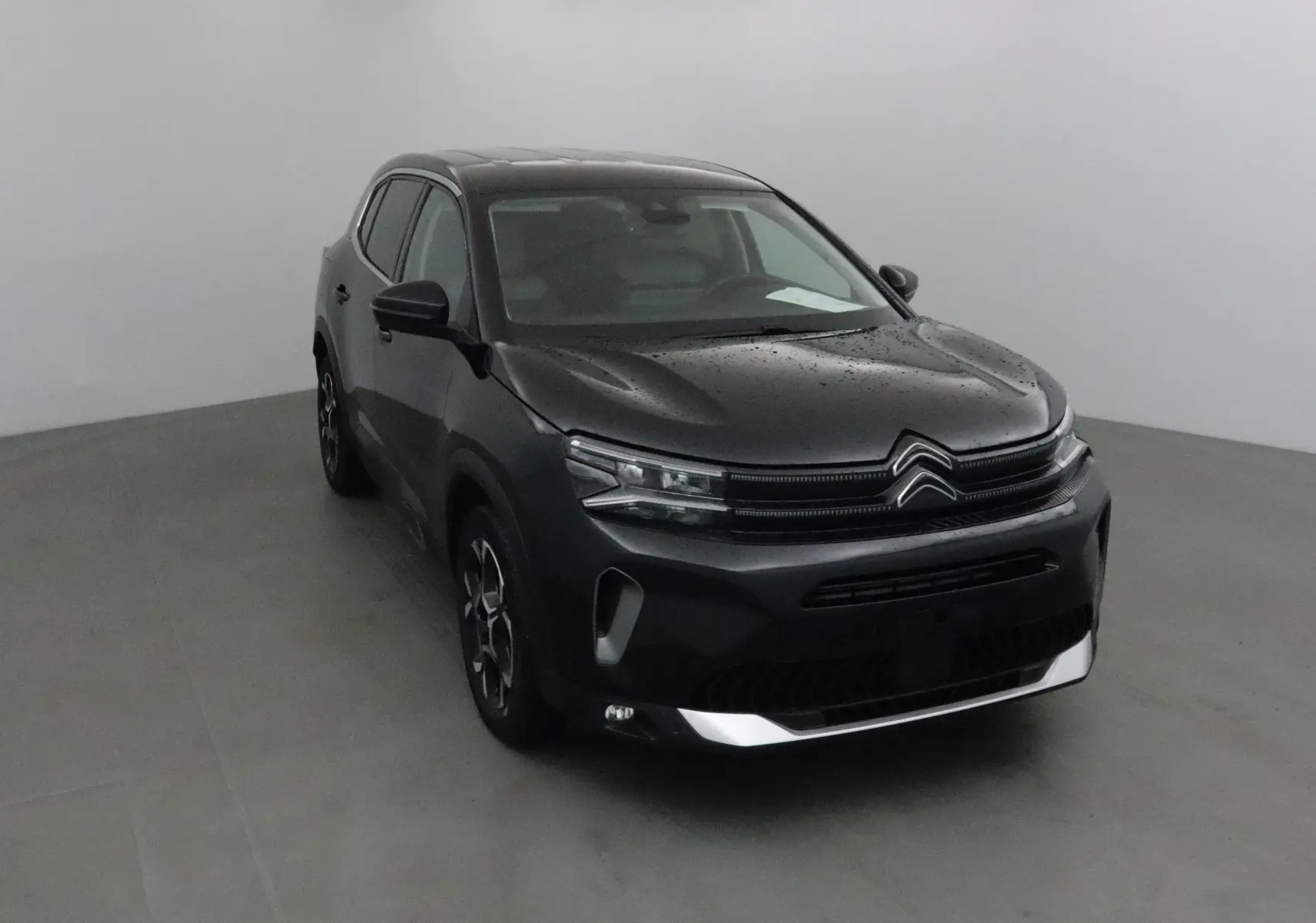 Citroën C5 Aircross noir vu en 3/4 avant droit, avec calandre distinctive et jantes alliage noires.
