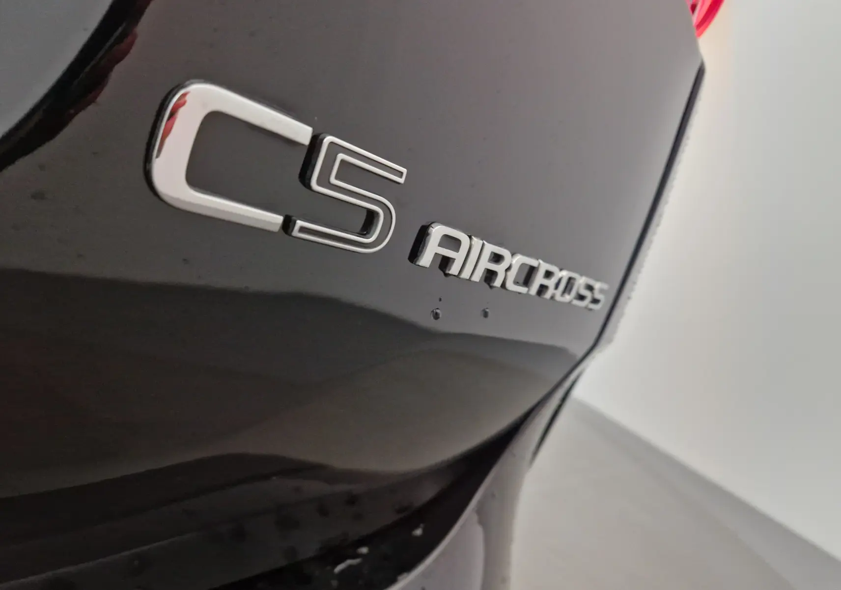 Gros plan sur l'arrière droit noir du Citroën C5 Aircross avec le logo du modèle en relief chromé.