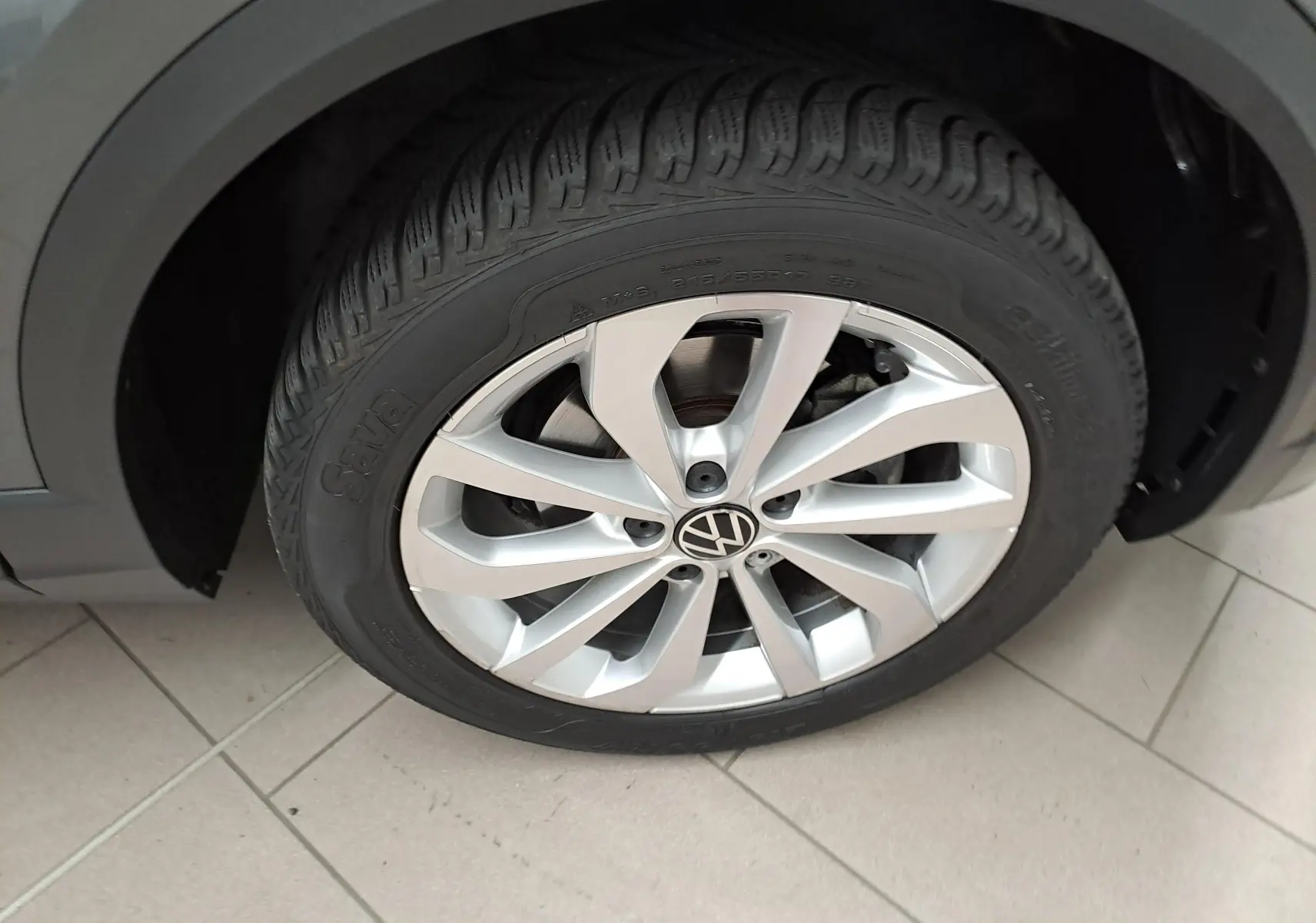 Gros plan sur la jante alliage 17'' Johannesburg et pneu du Volkswagen T-Roc gris Indium, côté avant droit.
