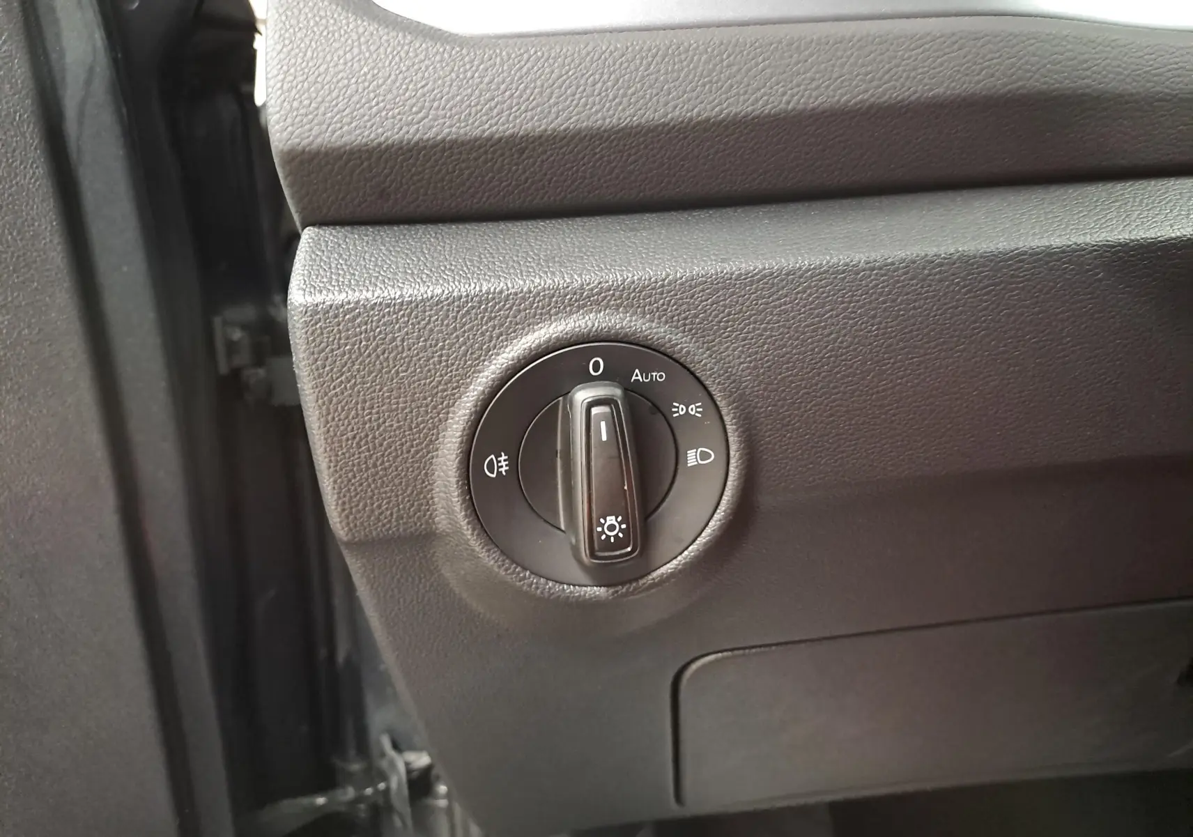 Commande des phares en gros plan sur tableau de bord noir du Volkswagen T-Roc 2024 gris Indium