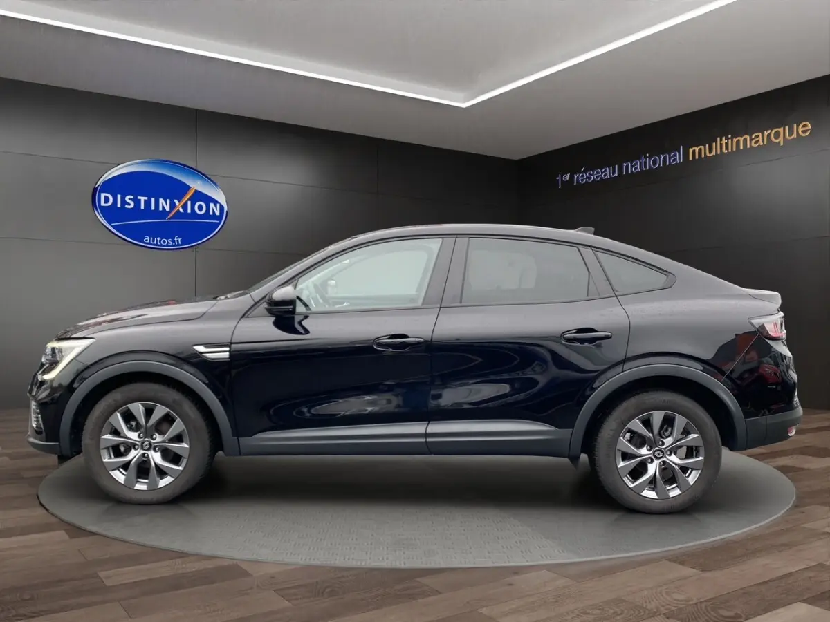Profil droit du Renault Arkana noir 2024 avec jantes alliage et lignes fluides dans un showroom moderne.