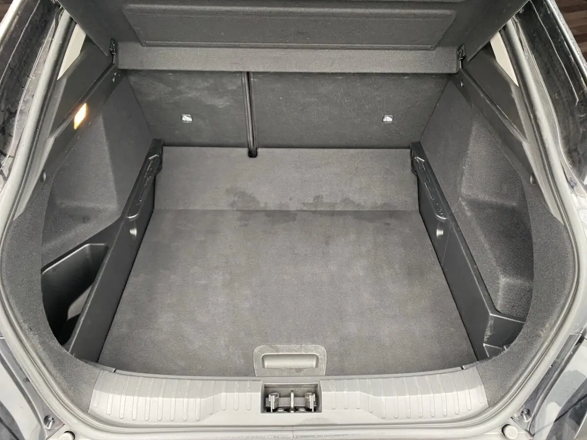 Coffre ouvert vu de dessus du Renault Arkana noir 2024, montrant un espace de chargement propre et spacieux.