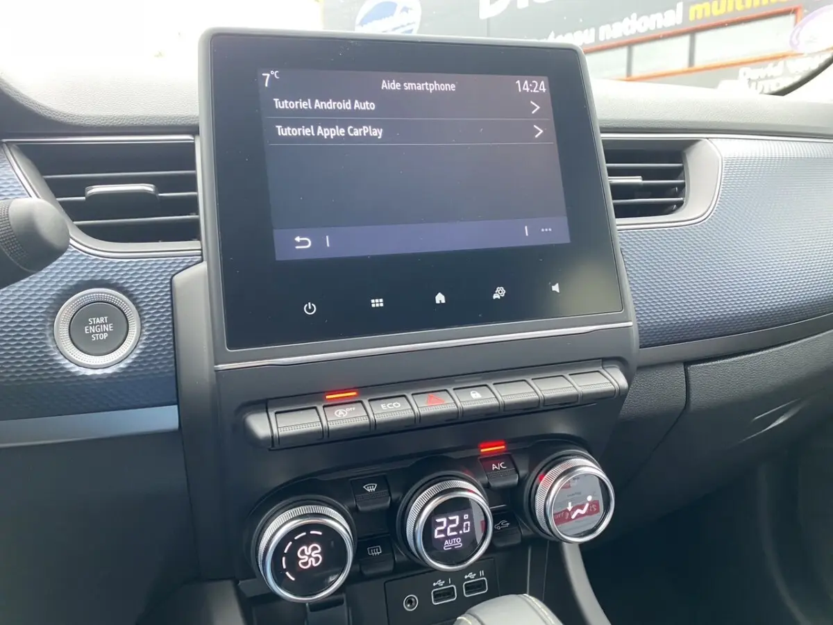 Vue rapprochée de la console centrale du Renault Arkana 2024 noire, écran tactile et commandes climatisation visibles.