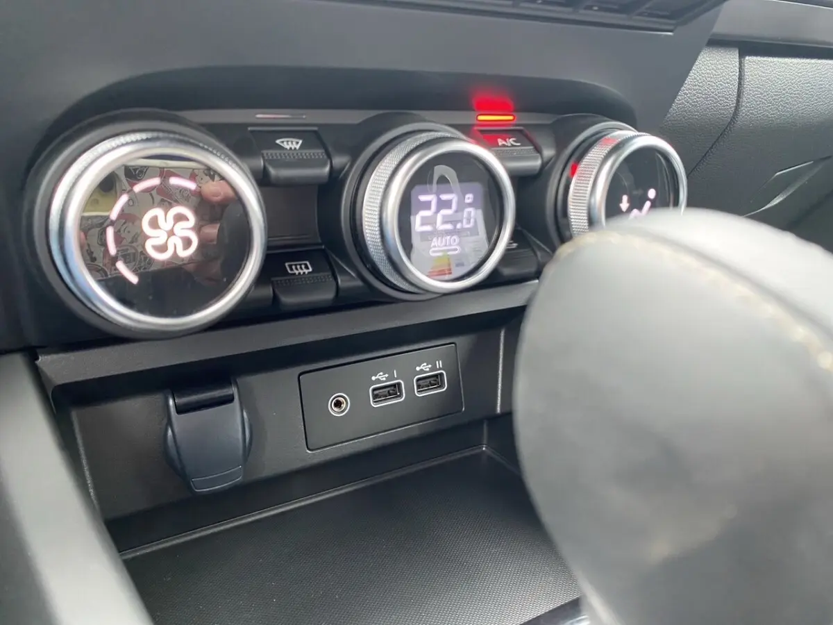Détail intérieur du tableau de bord du Renault Arkana 2024, montrant les commandes de climatisation et ports USB.