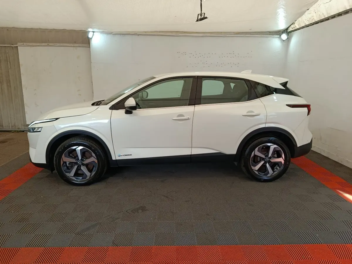 Profil droit du Nissan Qashqai e-Power blanc 2024, avec jantes alliage et logo e-Power visible sur la porte avant.