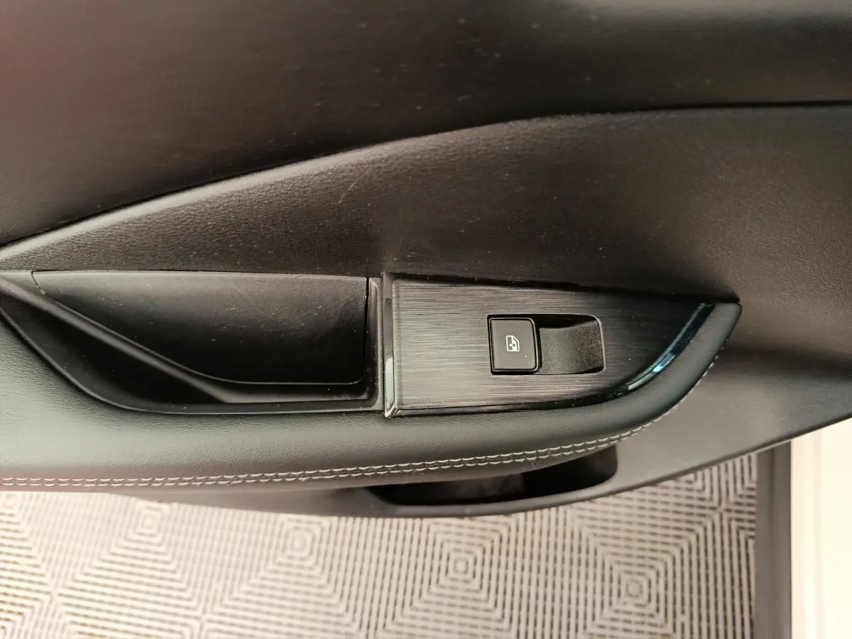 Gros plan sur la commande de verrouillage de porte côté conducteur du Nissan Qashqai e-Power blanc 2024.