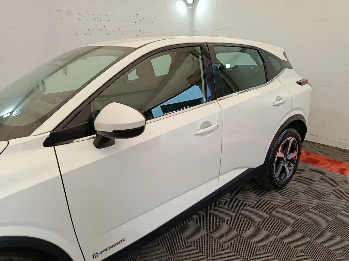 Vue côté gauche du Nissan Qashqai e-Power blanc, mettant en valeur la porte arrière, le rétroviseur et la jante alliage.