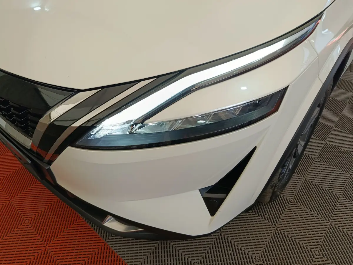 Gros plan sur l'avant droit blanc du Nissan Qashqai e-Power 190 avec phares LED et calandre chromée.