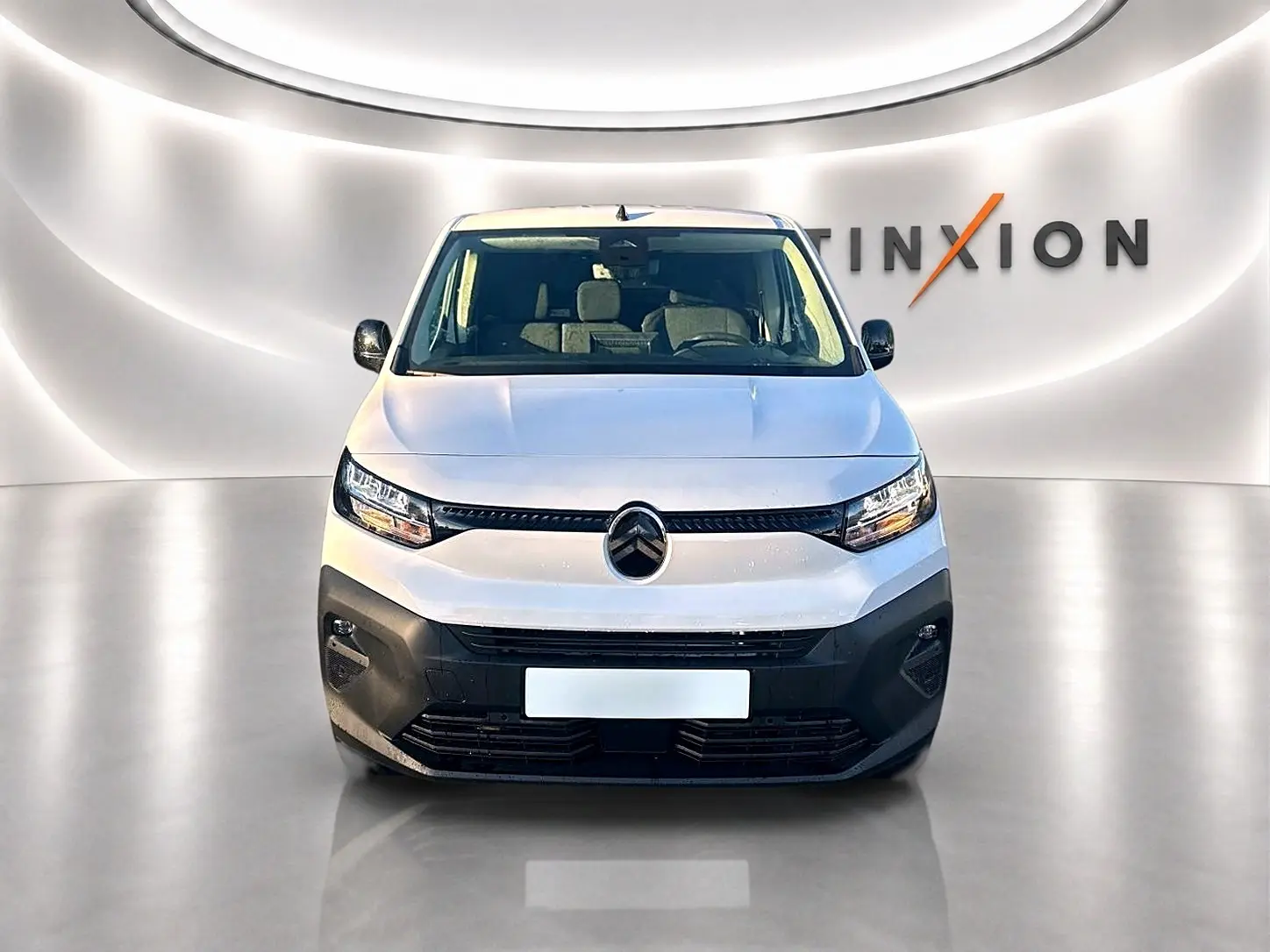 Vue frontale d'un Citroën Berlingo Fourgon blanc 2026 avec pare-chocs noir et phares LED dans un studio lumineux.