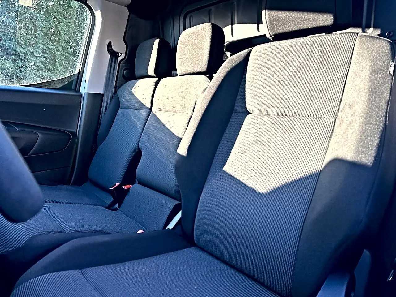 Vue intérieure rapprochée des sièges avant en tissu gris foncé du Citroën Berlingo Fourgon M diesel 100 2026.
