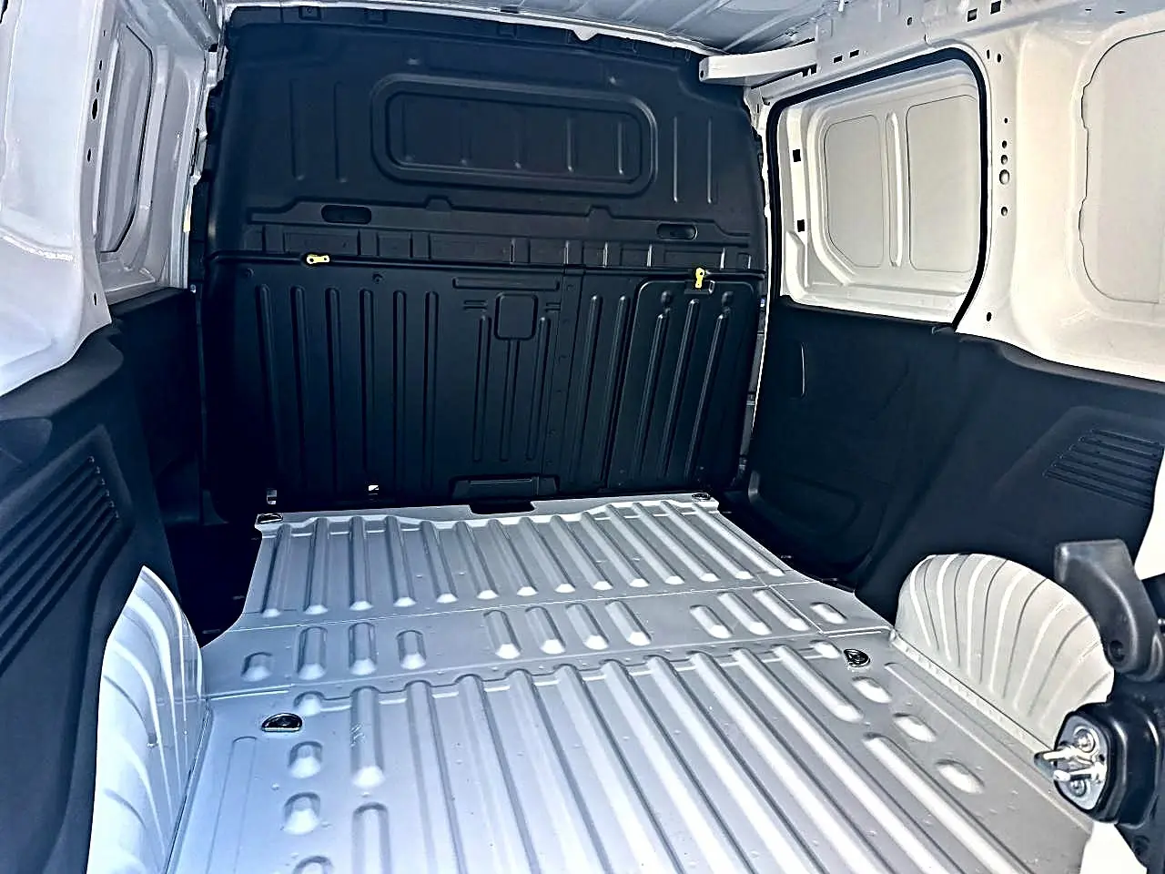 Vue intérieure arrière du coffre blanc du Citroën Berlingo Fourgon M diesel 100 avec cloison pleine noire.