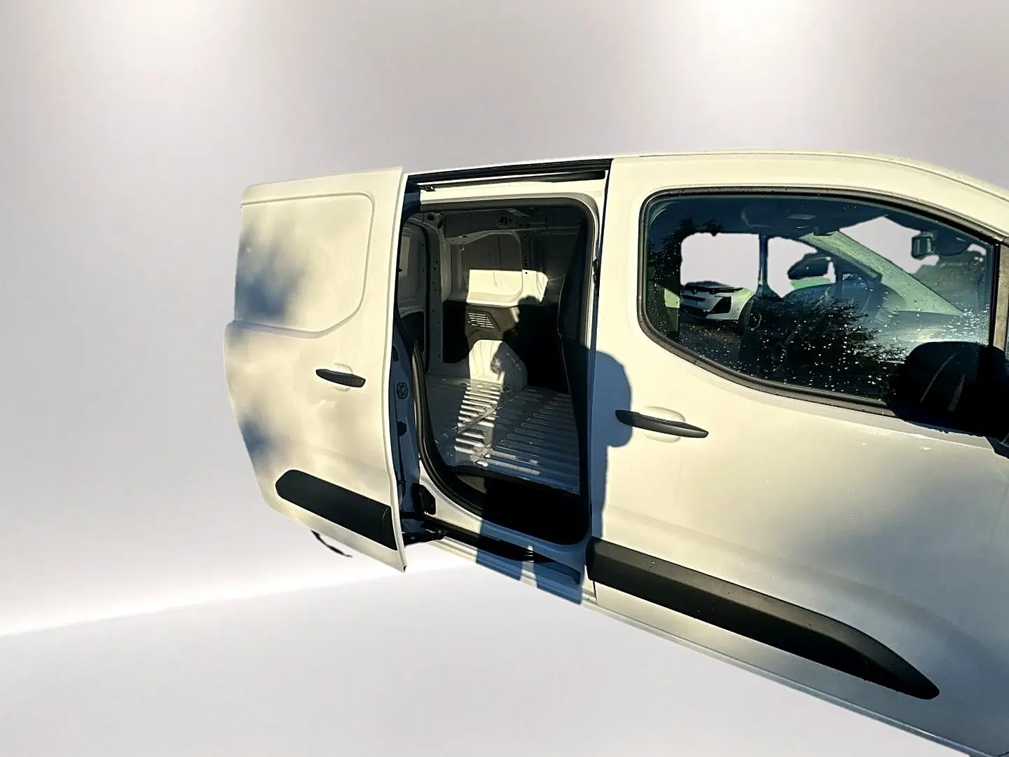 Vue latérale droite d'un Citroën Berlingo Fourgon blanc avec porte coulissante ouverte montrant l'espace de chargement.