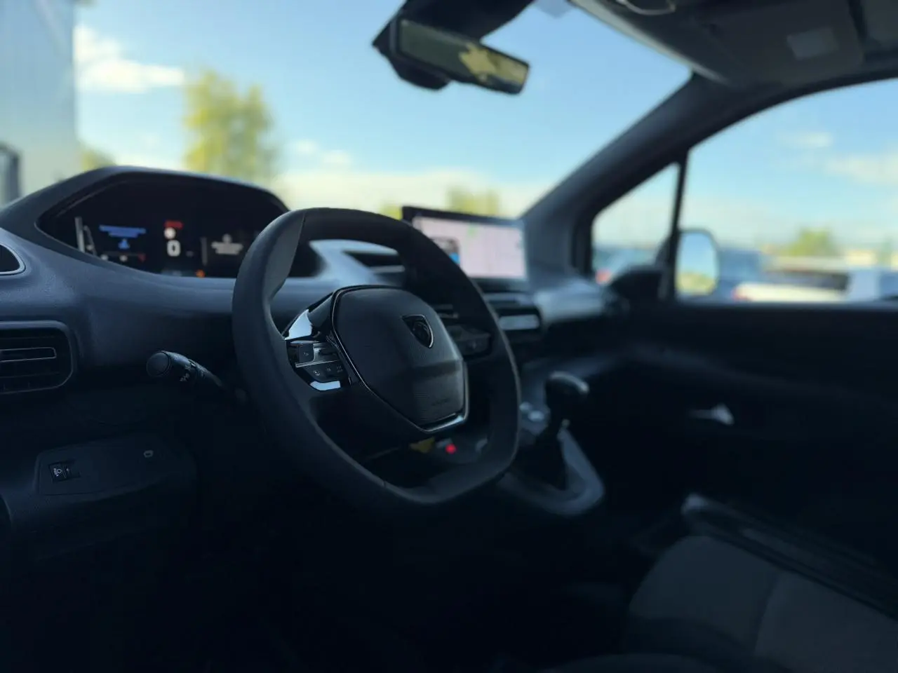 Vue intérieure côté conducteur du Peugeot Partner 2026, avec volant multifonctions et écran tactile central visible.