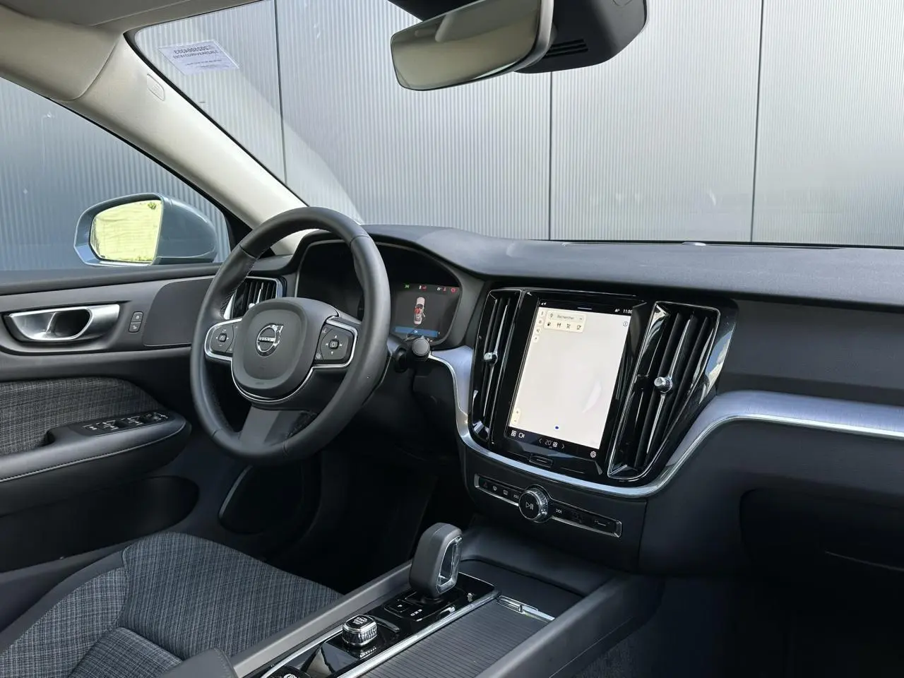 Intérieur avant droit de la Volvo S60 gris Thunder 2024, volant multifonction et écran tactile central visible