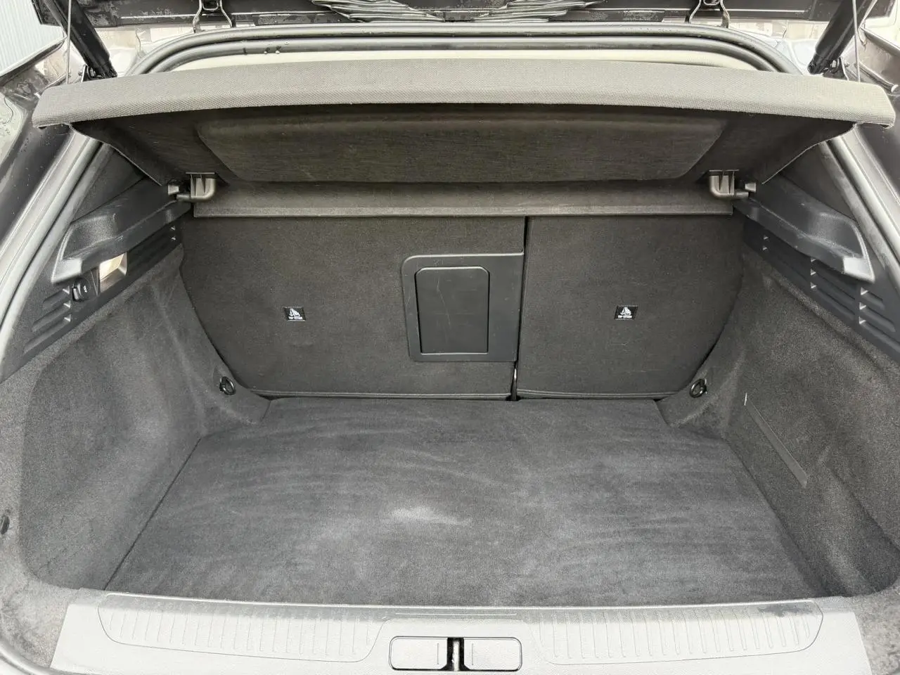 Coffre ouvert en vue arrière d'un DS4 2025 gris Platinium, montrant un espace de chargement propre et spacieux.