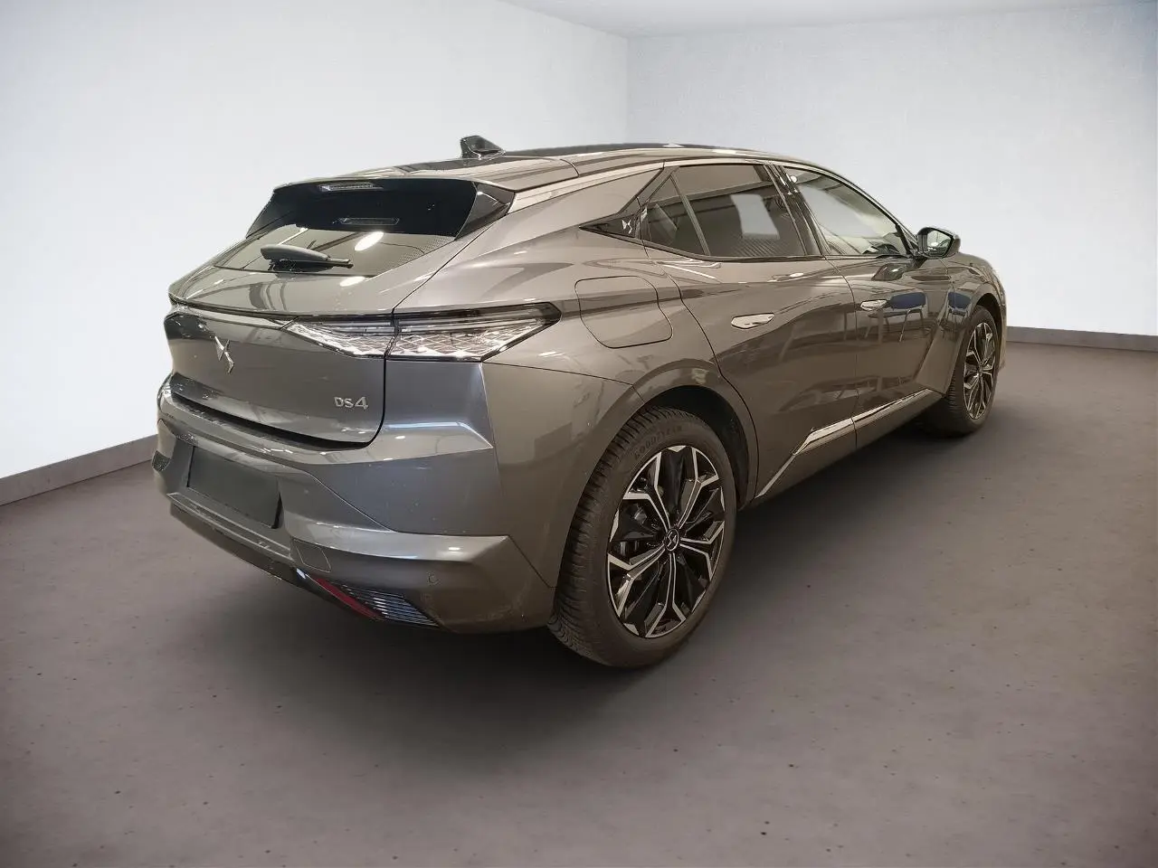 DS4 2025 gris Platinium en 3/4 arrière droit, avec jantes alliage et vitres teintées sur fond neutre.