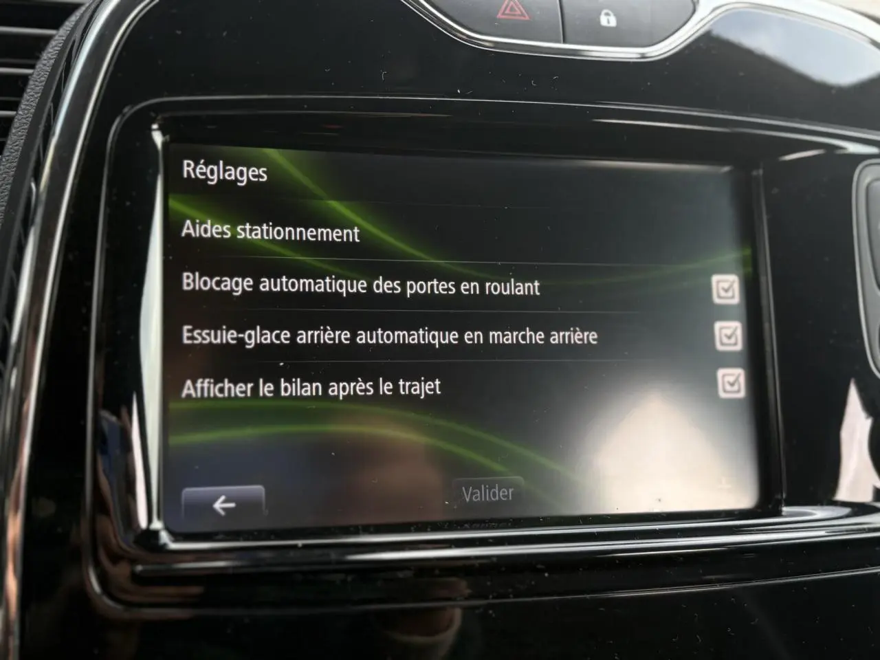 Écran tactile central du Renault Captur 1.5 DCI 90 EDC Intens affichant les réglages d'aides au stationnement.