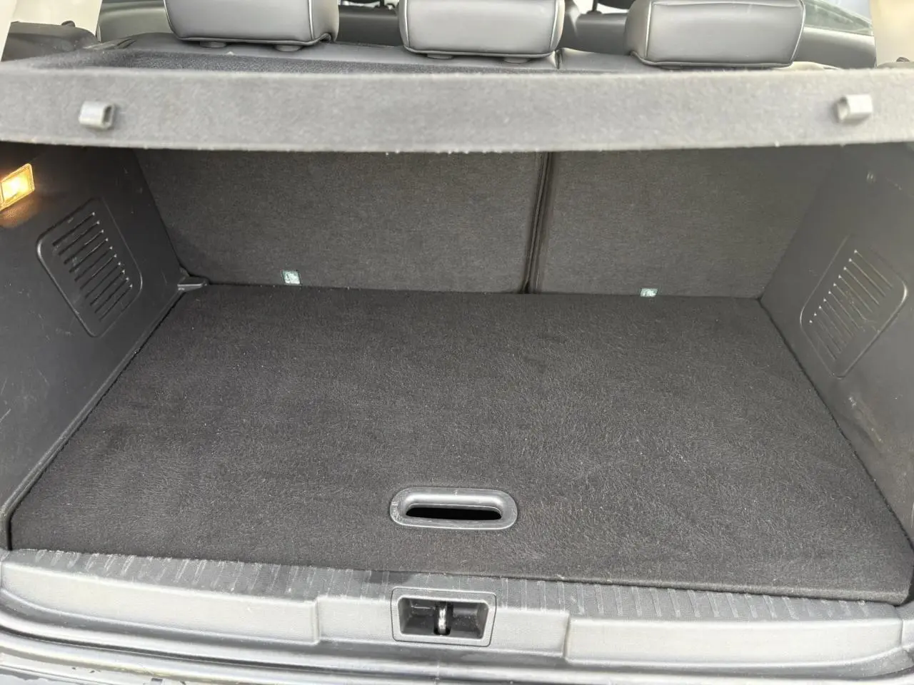 Vue intérieure du coffre du Renault Captur 2017, montrant un espace de rangement propre et bien fini en tissu noir.