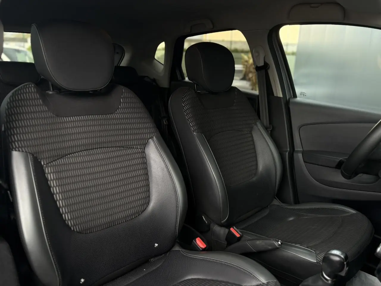 Vue intérieure des sièges avant noirs en TEP/textile du Renault Captur 1.5 dCi 90 Intens, côté conducteur et passager.
