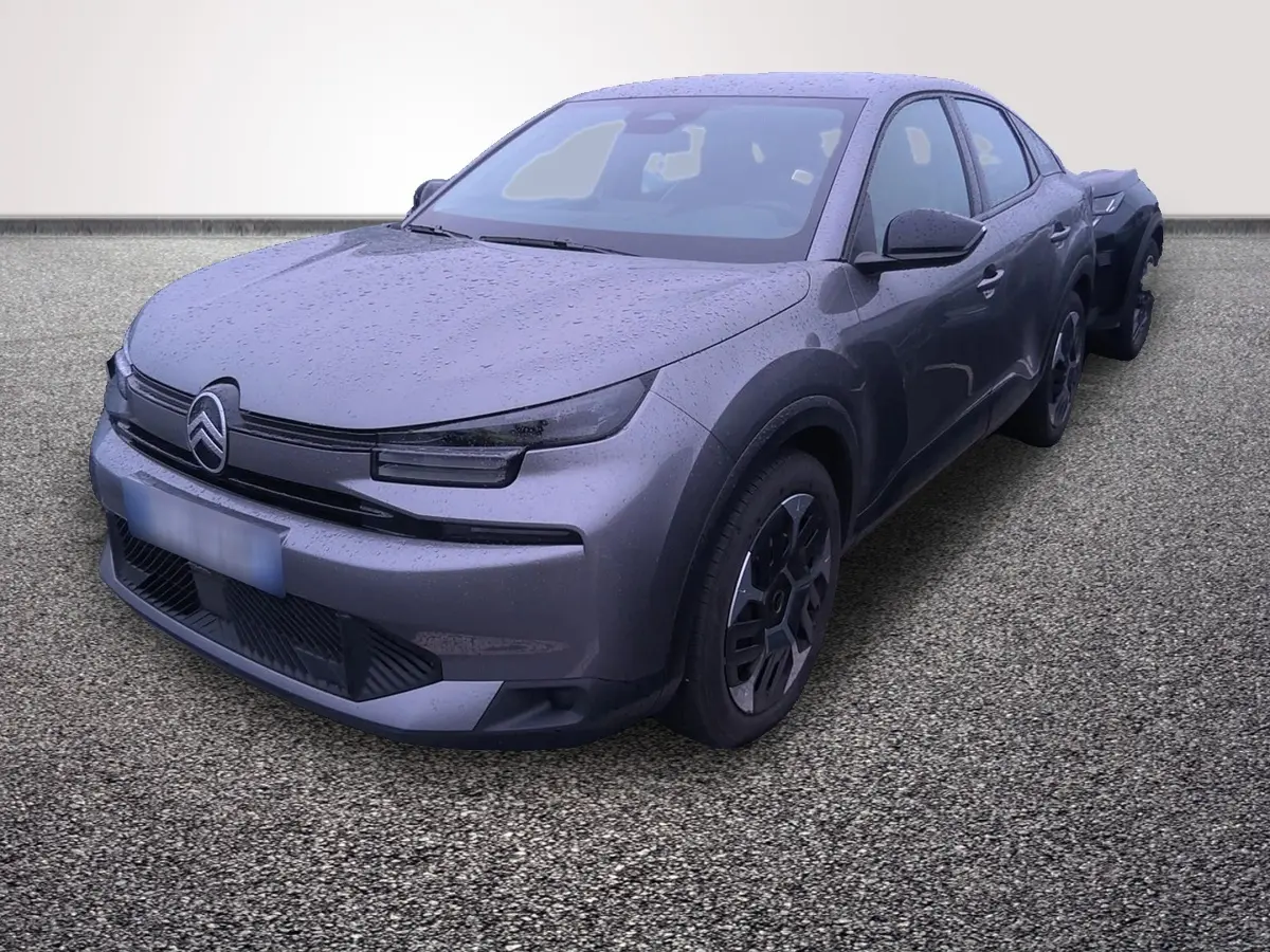 Vue 3/4 avant droite d'une Citroën C4 hybride gris foncé avec pluie visible sur la carrosserie.