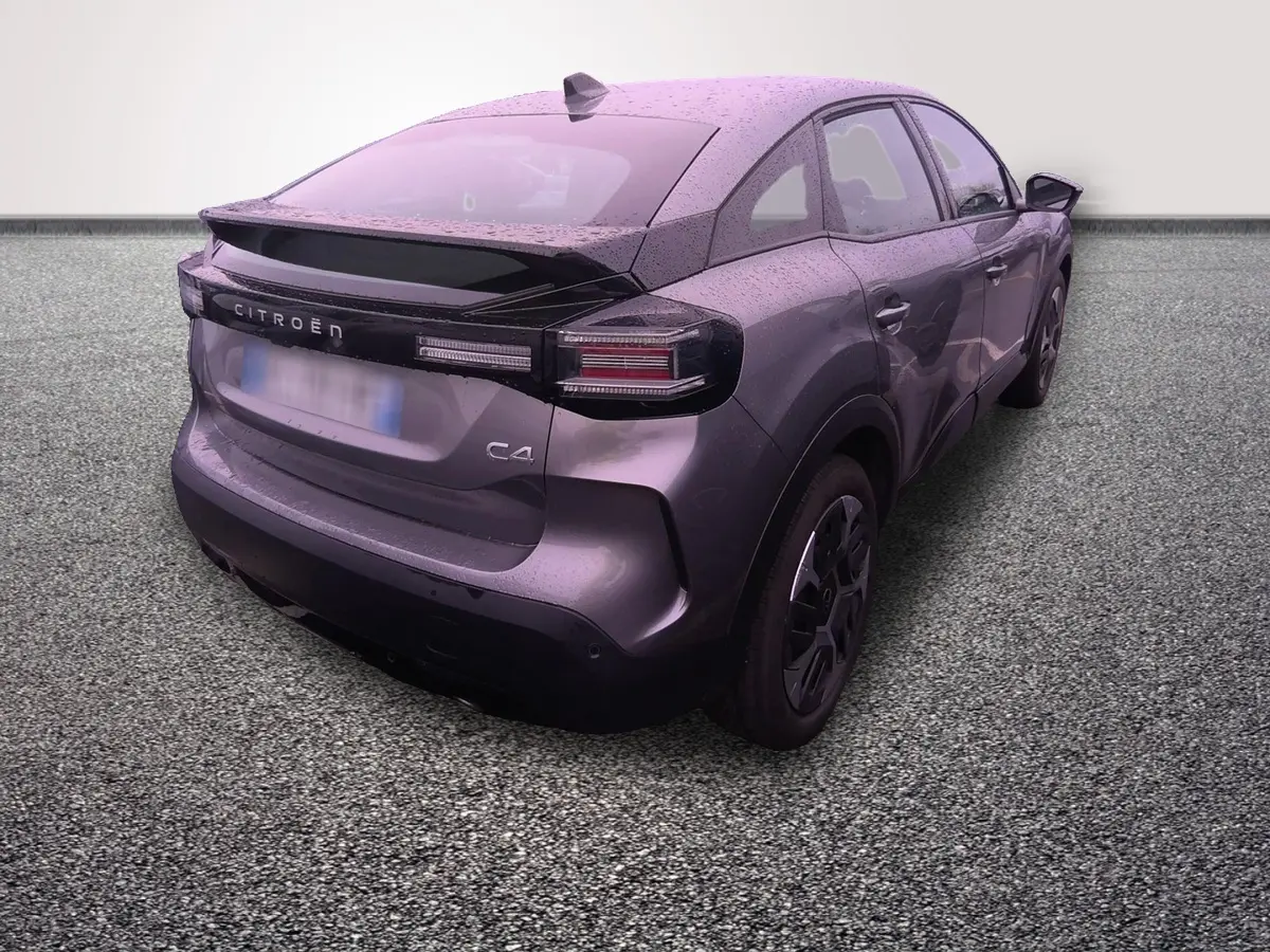 Vue 3/4 arrière droite d'une Citroën C4 hybride gris foncé avec spoiler et feux arrière LED distinctifs.