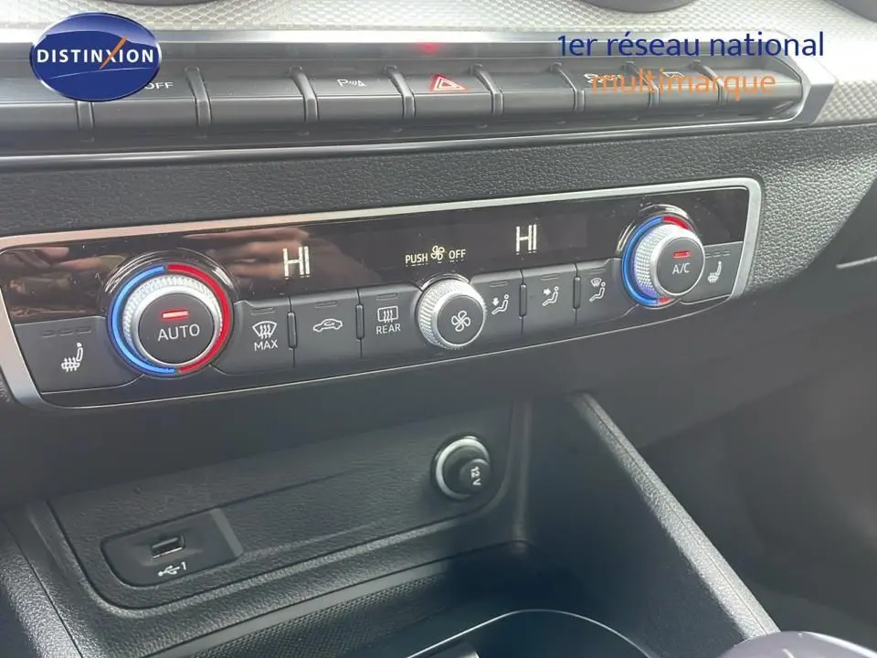 Tableau de bord de l'Audi Q2 35 TFSI 2023, zoom sur la climatisation automatique avec réglages chauffants et USB.