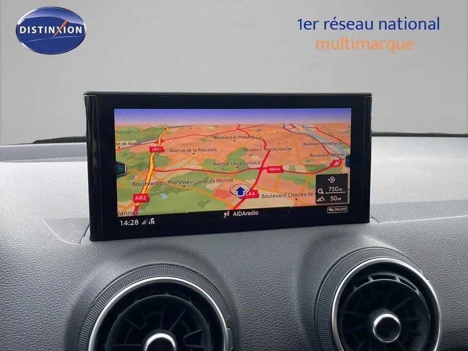 Écran central du tableau de bord de l'Audi Q2 2023 noir, affichant la navigation GPS avec carte routière colorée.