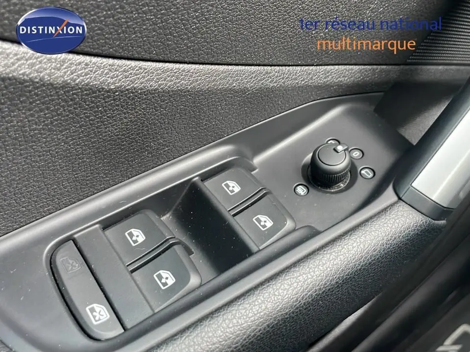 Gros plan sur les commandes des vitres et rétroviseurs côté conducteur d'un Audi Q2 noir mito metal 2023.