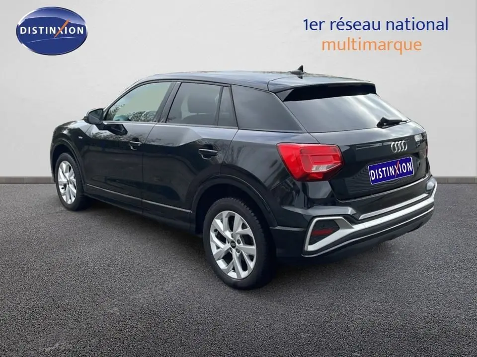 Audi Q2 noir mito métal vue 3/4 arrière côté gauche, avec jantes argentées et feux arrière rouges distinctifs.