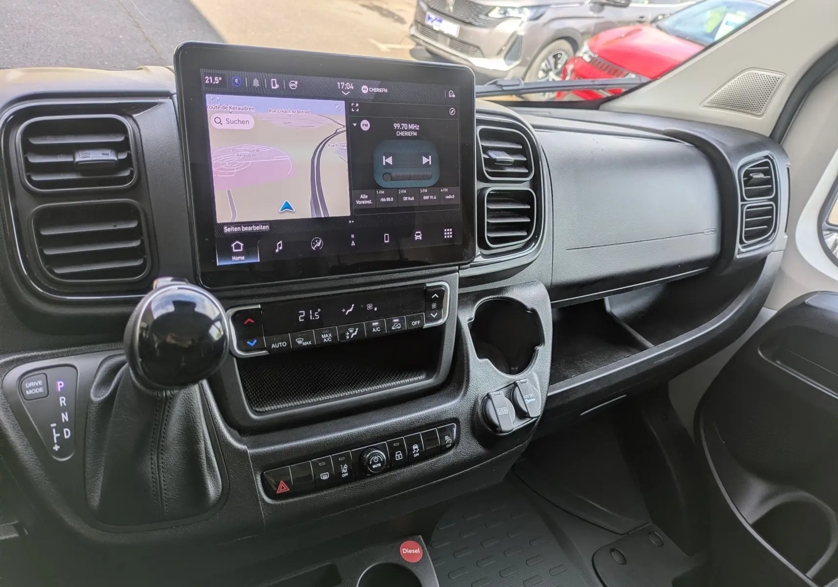 Vue intérieure du tableau de bord du Peugeot Boxer Fourgon blanc, avec écran tactile central et levier de vitesses automatique.