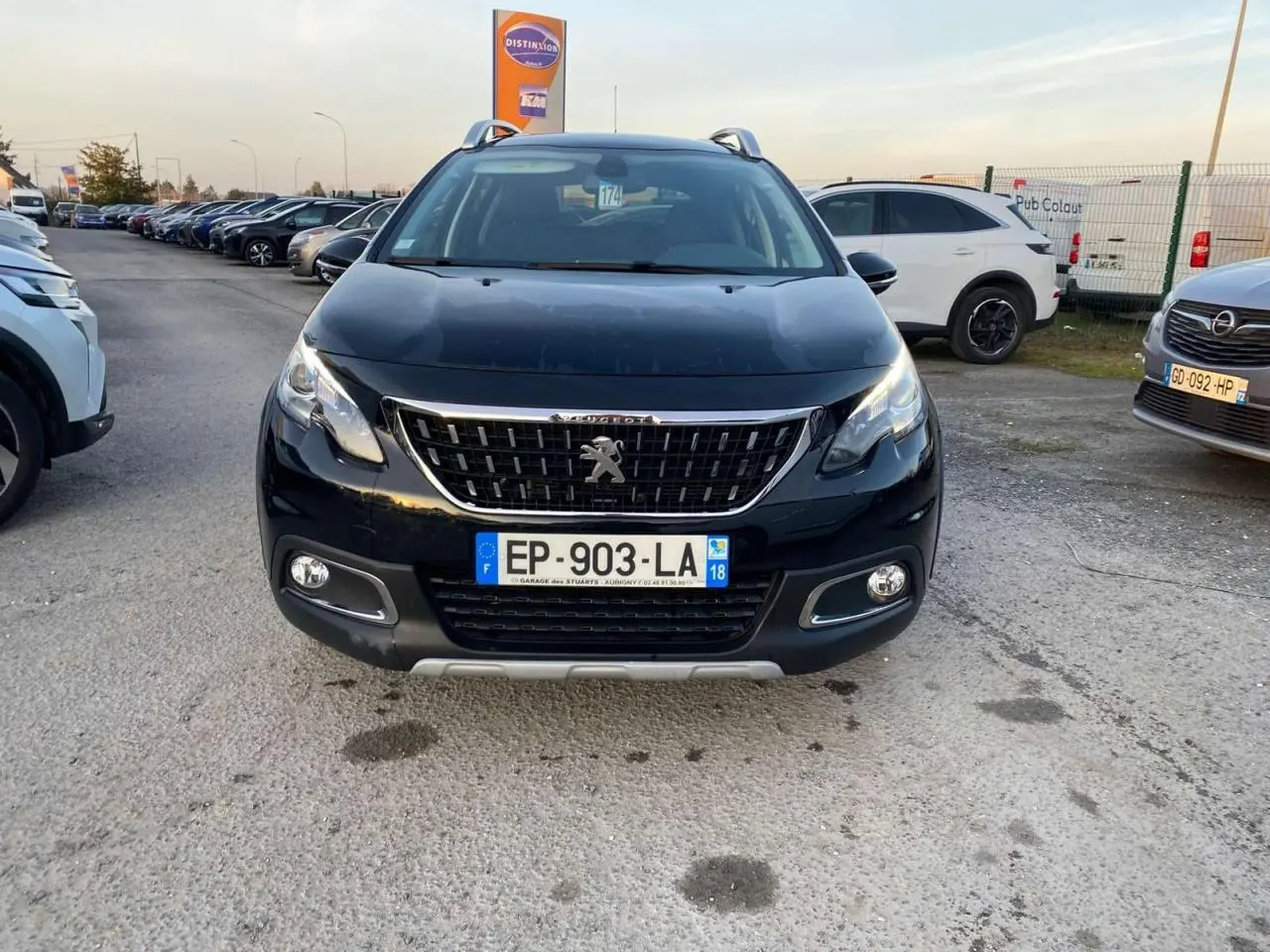 Vue frontale d'un Peugeot 2008 noir Perla Nera 2017 avec calandre chromée et feux diurnes LED allumés.