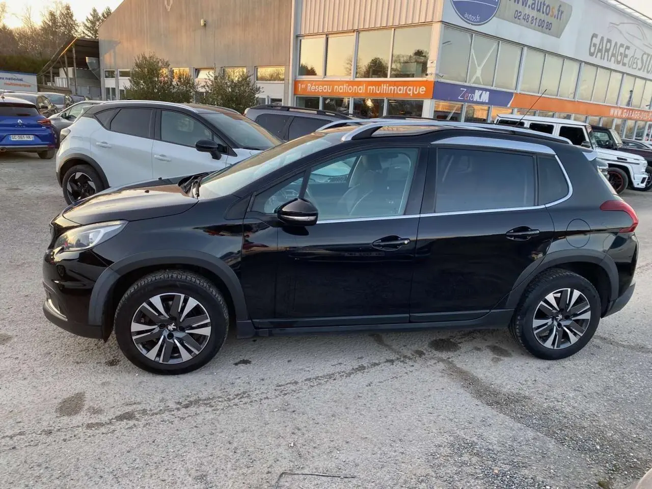 Profil côté gauche du Peugeot 2008 noir Perla Nera de 2017 avec jantes aluminium et bas de caisse noir mat.