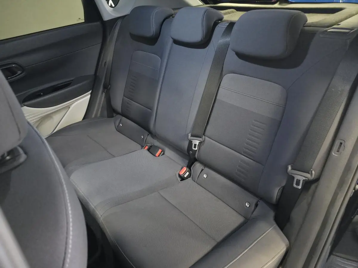 Vue intérieure du siège arrière noir du Hyundai Bayon 2025 avec ceintures de sécurité et appuie-têtes réglables.