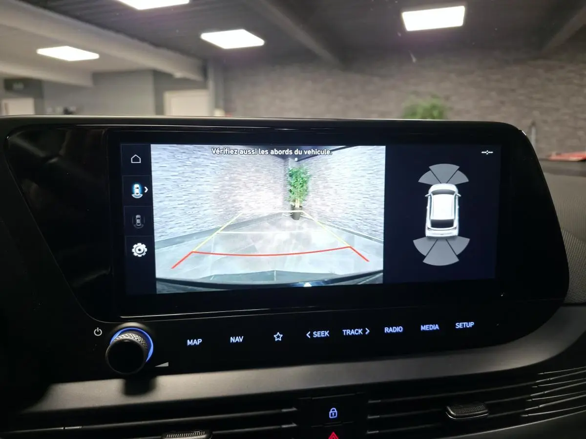 Écran tactile intérieur montrant la caméra de recul active avec vue arrière et capteurs de proximité du Hyundai Bayon noir.