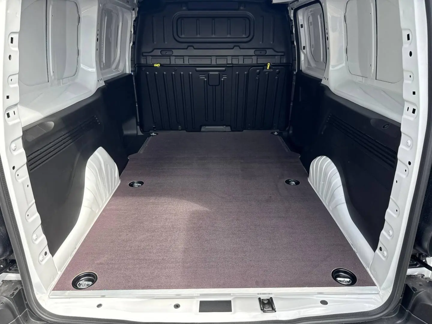 Vue intérieure arrière du Citroën Berlingo Fourgon XL blanc Icy, montrant l'espace de chargement vide avec revêtement au sol.