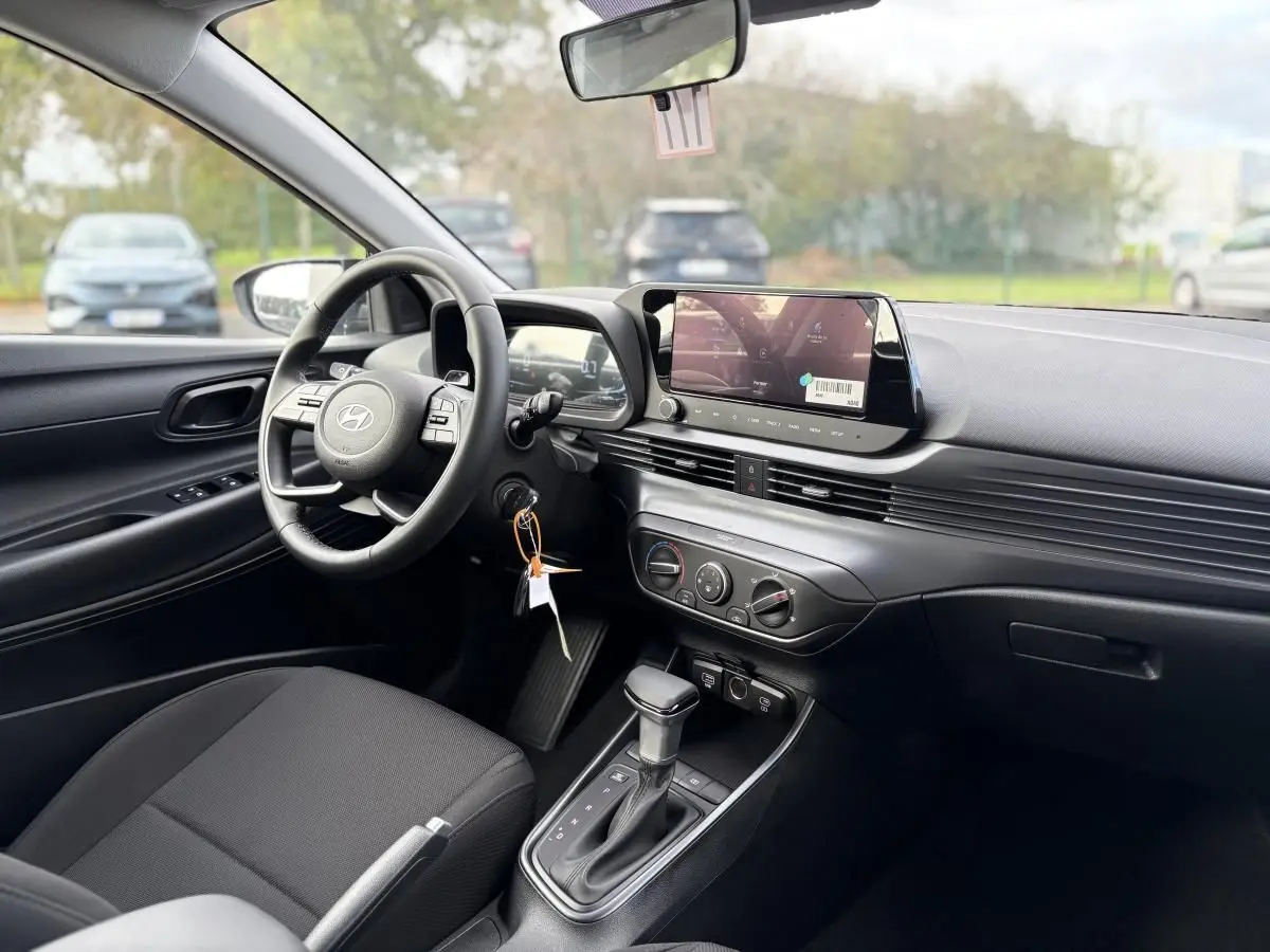 Vue intérieure côté conducteur de la Hyundai i20 2026 noire métal, avec tableau de bord moderne et écran tactile central.