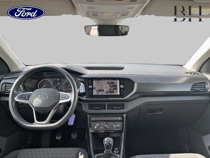 Intérieur avant du Volkswagen T-Cross gris cendré, volant cuir multifonction et écran tactile central visible.