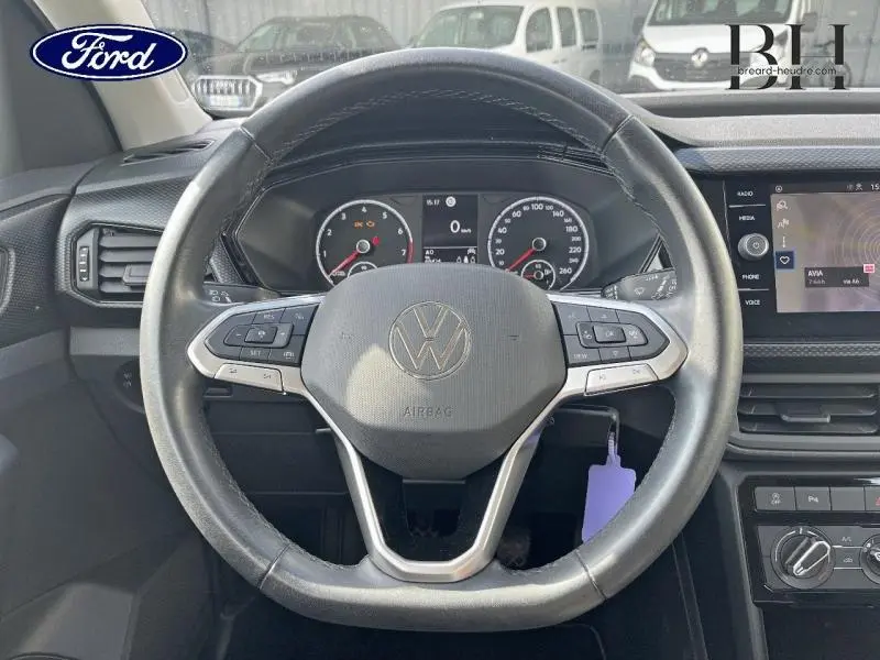 Vue frontale du volant cuir multifonction d'un Volkswagen T-Cross gris cendré avec tableau de bord et écran tactile visibles.